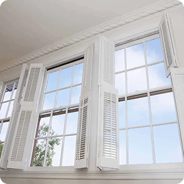 White interior shutters installed on large bright windows