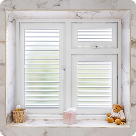White cafe shutters installed on a marble bathroom window