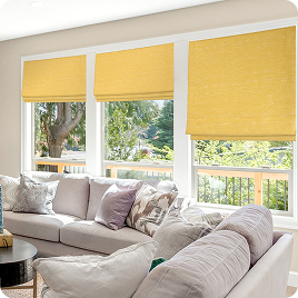 Yellow roller shades installed across bright living room windows